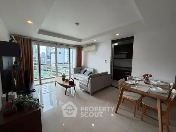 Modern living room with open layout and city view, featuring stylish furniture and dining area.
