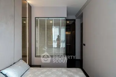 Modern bedroom with sleek design and large window for natural light.
