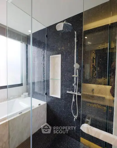 Luxurious modern bathroom with glass shower and elegant black tile design.