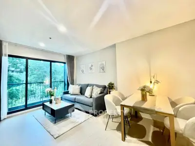 Modern living room with cozy seating and dining area, large windows with garden view.