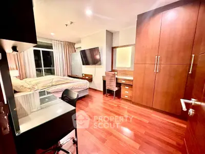 Spacious bedroom with wooden flooring and modern furniture in luxury apartment