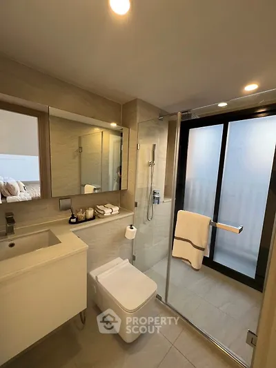 Modern bathroom with glass shower and sleek fixtures in a contemporary apartment.