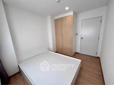 Modern minimalist bedroom with wooden flooring and built-in wardrobe