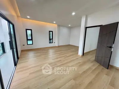 Spacious modern living room with wooden flooring and large windows