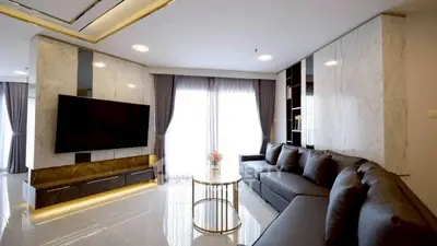 Luxurious modern living room with sleek marble accents and large sectional sofa, perfect for relaxation.