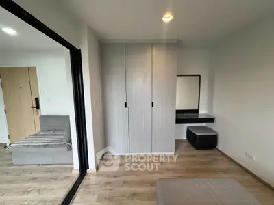 Modern apartment interior with sleek wardrobe and cozy seating area, perfect for urban living.