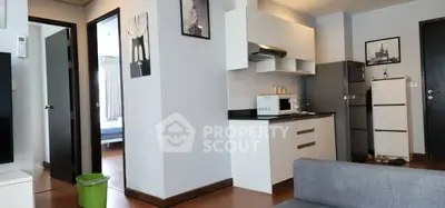 Modern apartment interior with compact kitchen and cozy living area, featuring stylish decor and natural light.