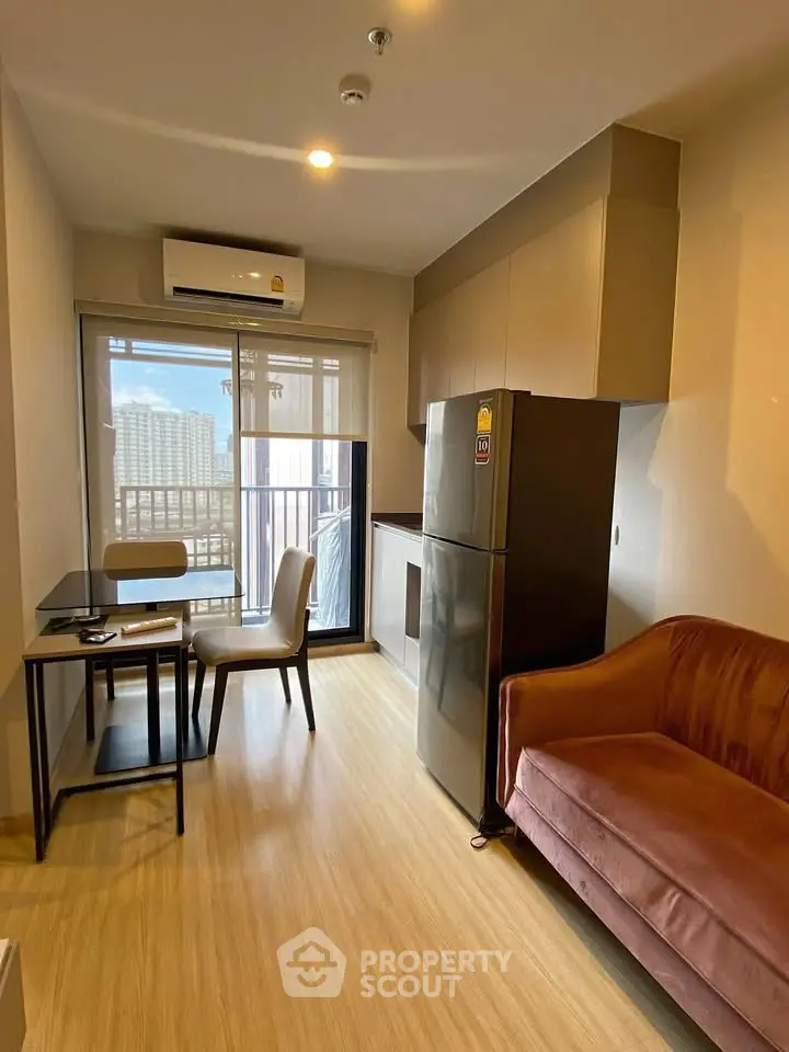 Modern apartment interior with cozy living area and kitchen, featuring a large window view.