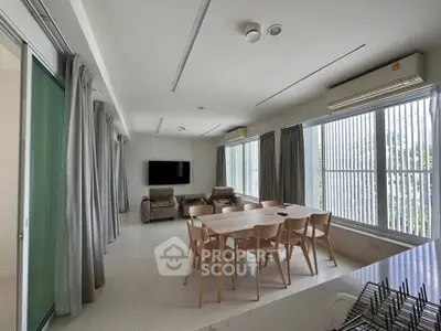 Spacious modern living room with dining area and large windows for natural light.