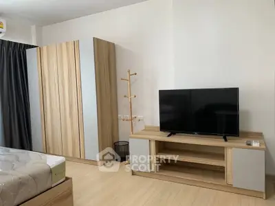 Modern bedroom with wooden furniture and flat-screen TV, perfect for cozy living.