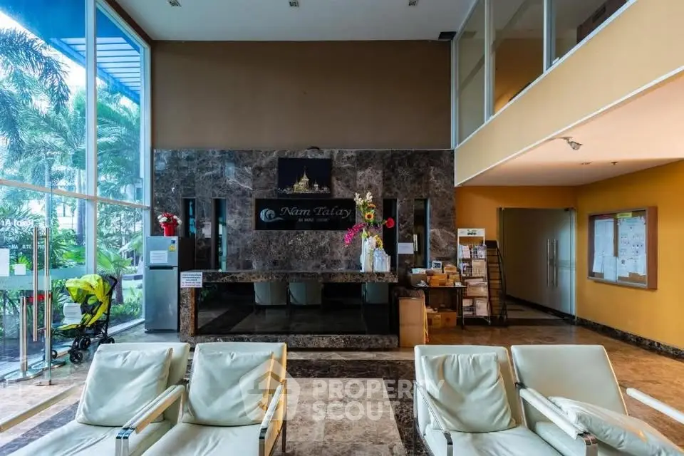 Luxurious building entrance with modern design and elegant seating area.