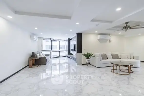 Spacious modern living room with elegant marble flooring and stylish furniture.