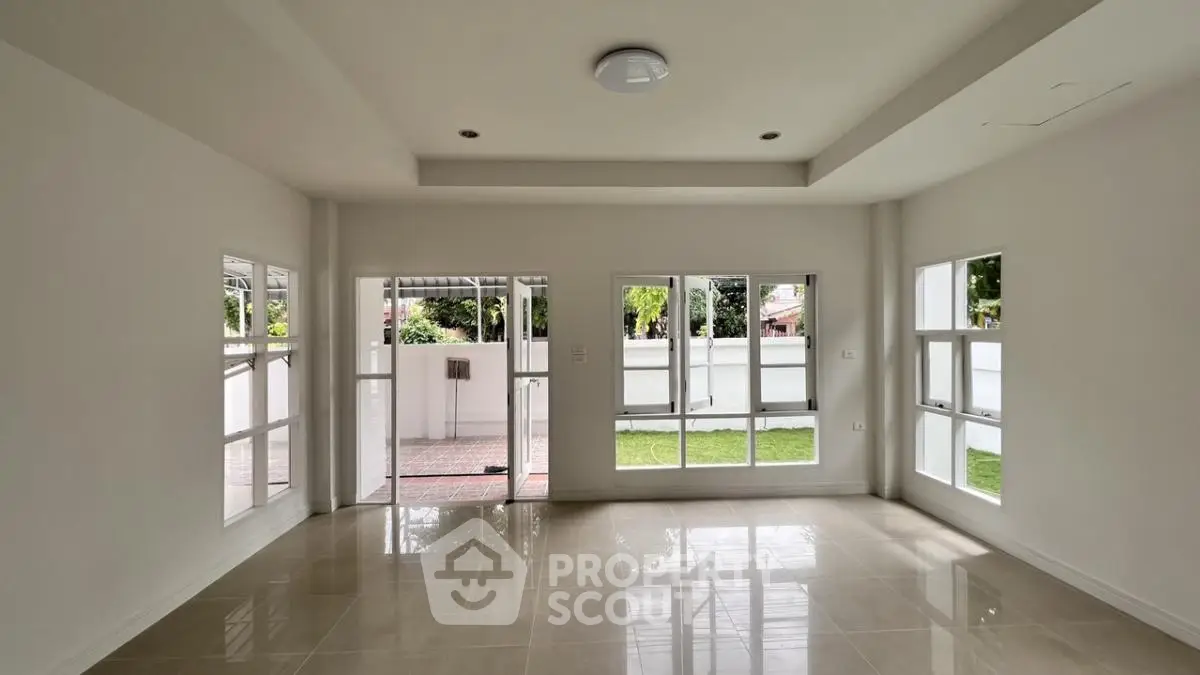 Spacious unfurnished living room with large windows and garden view