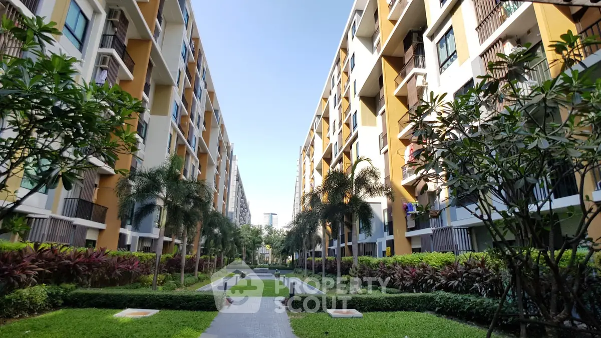 Stunning view of modern apartment buildings with lush gardens and palm trees.