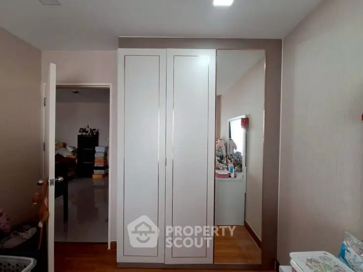 Modern bedroom with sleek wardrobe and wooden flooring