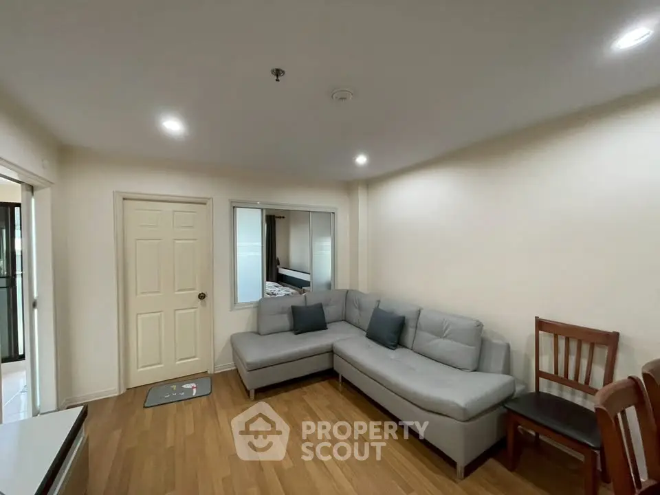 Cozy living room with modern gray sectional sofa and wooden flooring