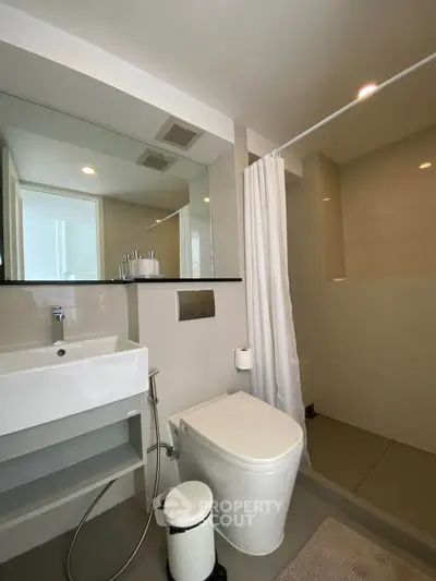Modern bathroom with sleek fixtures and spacious shower area in a contemporary apartment.
