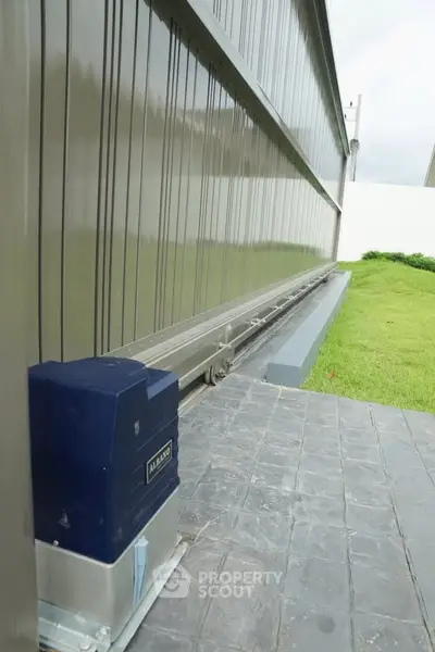 Modern automated sliding gate with sleek design and secure mechanism in a residential property.