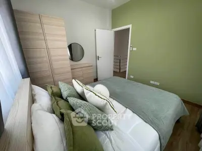 Cozy bedroom with green accents and modern furnishings, perfect for relaxation.