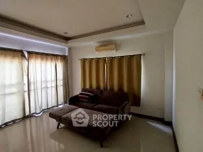 Spacious living room with modern sofa and large windows for natural light.