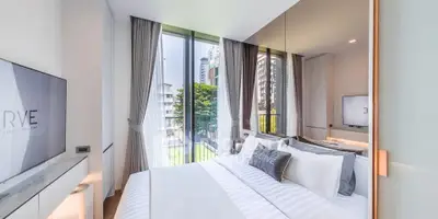 Luxurious modern bedroom with floor-to-ceiling windows and city view in high-rise apartment.