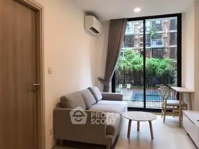 Modern living room with pool view, featuring a cozy sofa and stylish decor.
