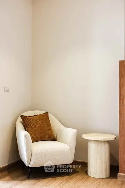 Cozy corner with a modern armchair and side table, perfect for relaxation in a stylish home.