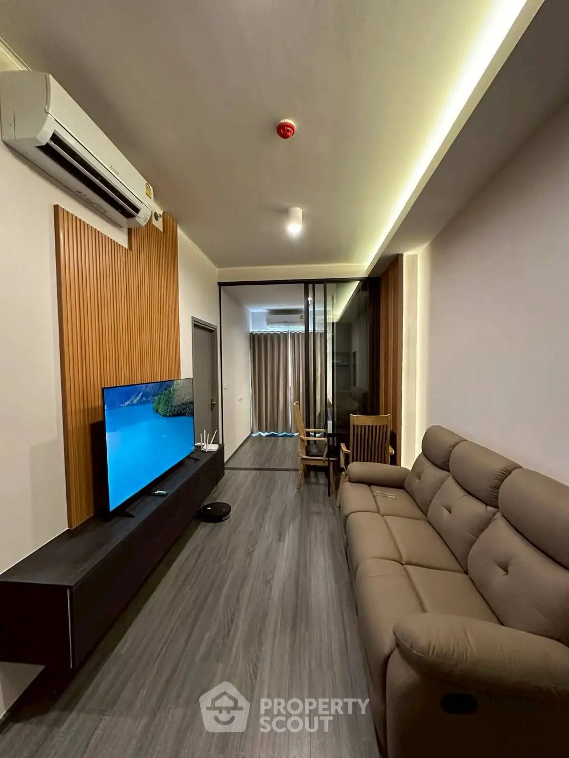 Modern living room with sleek design, featuring a comfortable sofa and large TV, perfect for relaxation.