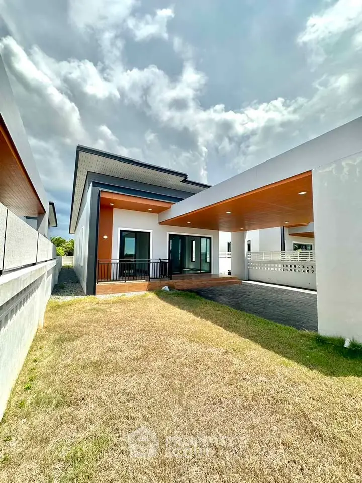 Modern single-story house with spacious driveway and contemporary design.