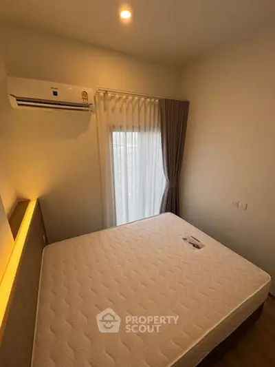 Cozy bedroom with natural light and modern air conditioning unit.