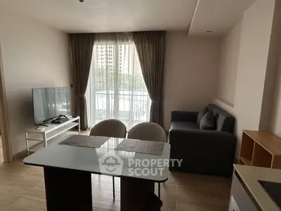 Modern living room with large window, cozy sofa, and sleek TV setup, perfect for relaxation and entertainment.