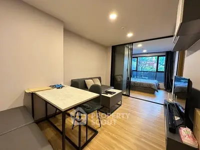 Modern open-plan living room with dining area and bedroom view