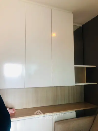 Modern study area with sleek white cabinets and wooden desk