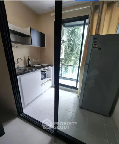 Compact kitchen with modern appliances and balcony view