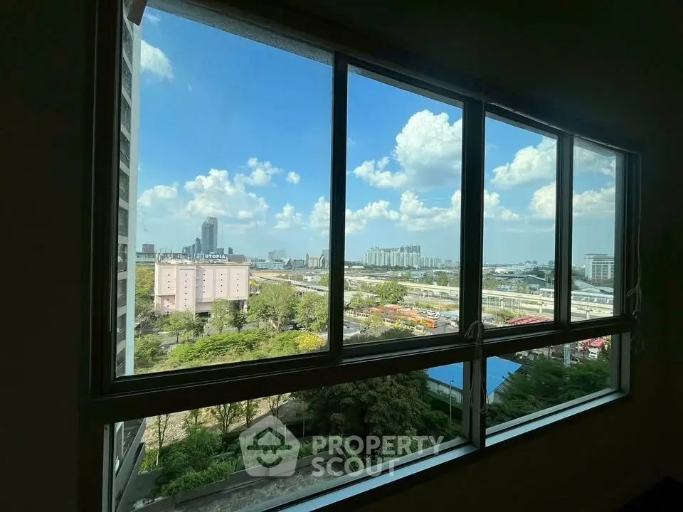 Stunning cityscape view from a large window, showcasing urban skyline and blue skies.