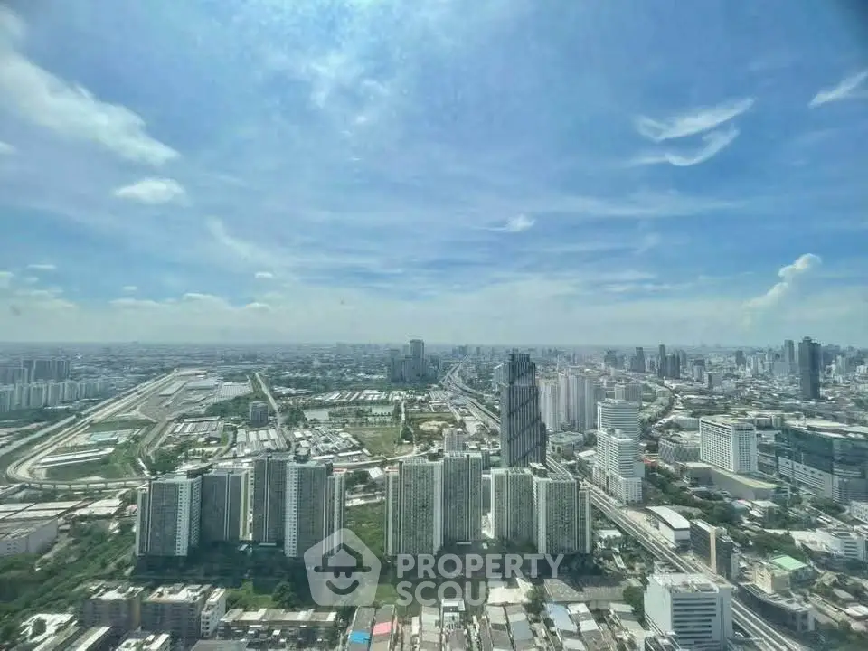 Stunning cityscape view from a high-rise building, showcasing urban skyline and clear blue skies.