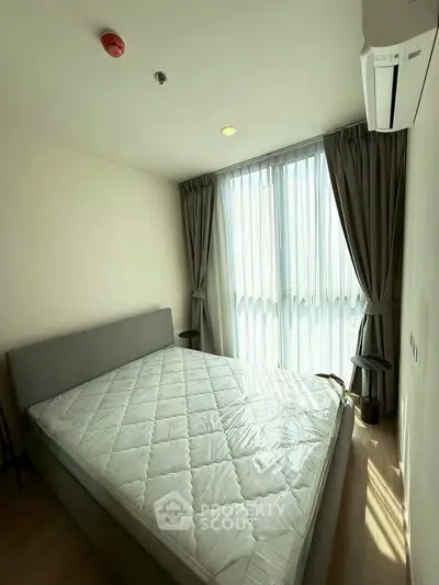 Cozy bedroom with natural light and modern furnishings in a stylish apartment.