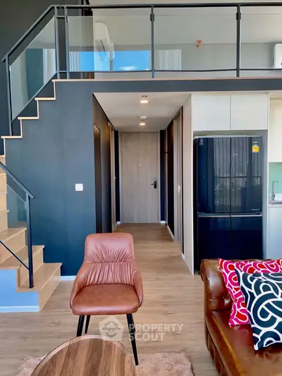 Modern loft apartment with stylish interior, featuring a mezzanine and sleek kitchen design.