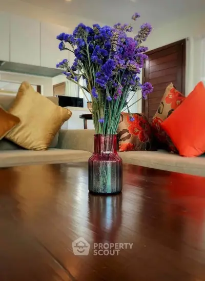 Stylish living room with vibrant floral centerpiece and cozy cushions on a modern sofa.