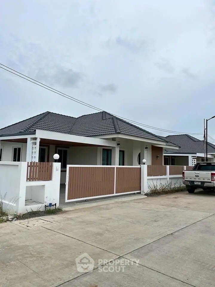 Charming single-story house with modern design and spacious driveway in a serene neighborhood.