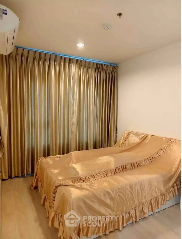 Cozy bedroom with elegant golden curtains and matching bedspread, perfect for relaxation.