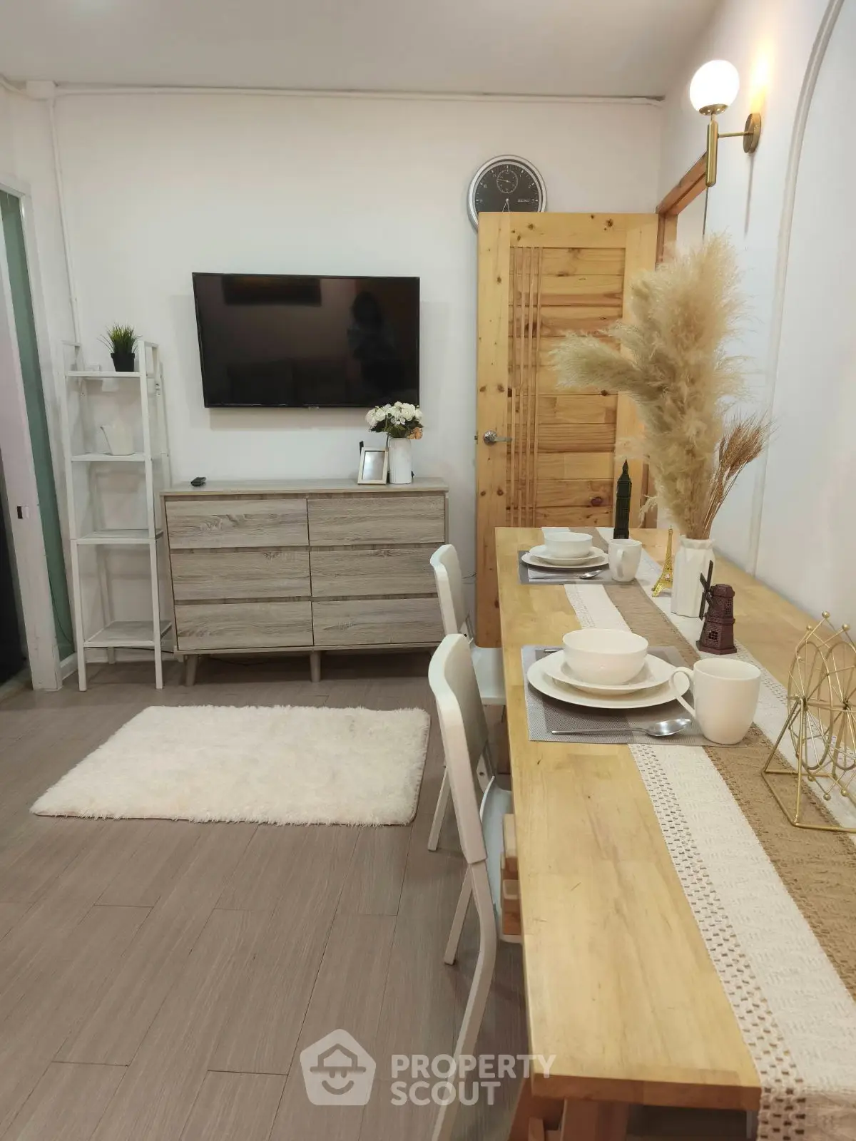 Charming living room with modern decor, wall-mounted TV, and cozy dining area.