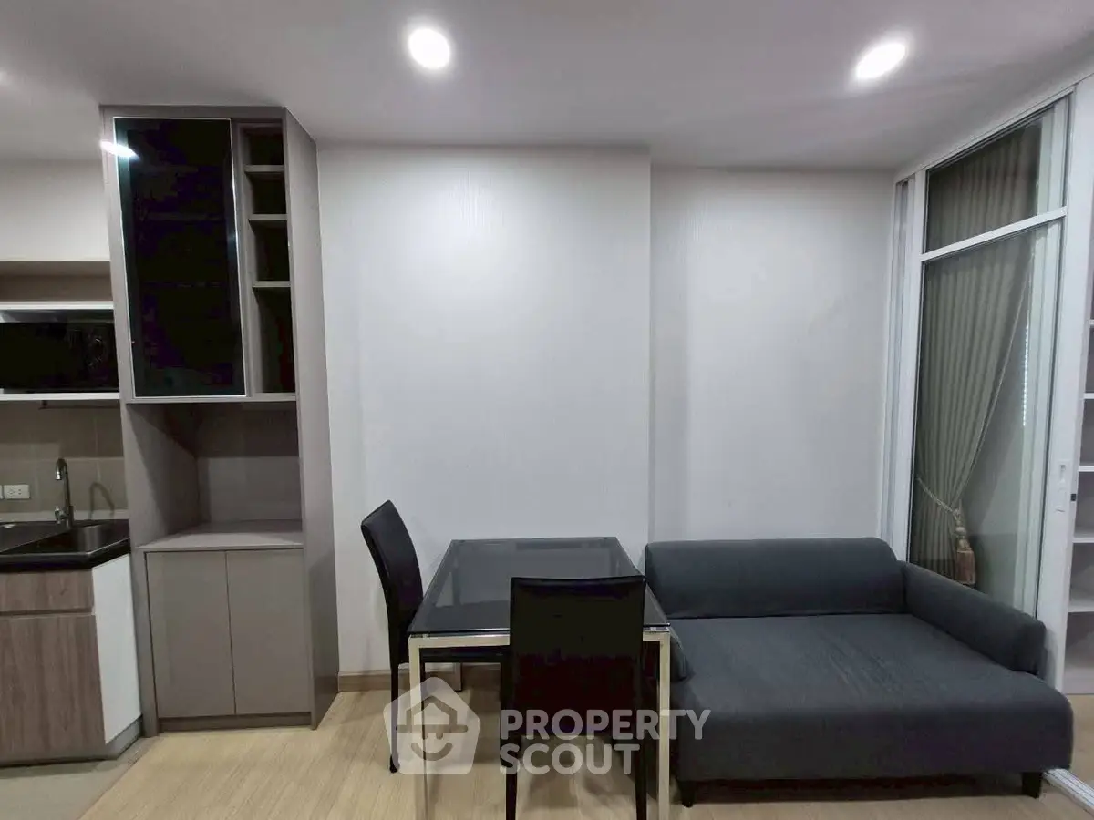 Modern living room with sleek furniture and open kitchen layout in a stylish apartment.