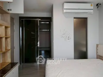 Modern bedroom with built-in shelves and air conditioning unit, featuring sleek design and ample storage space.