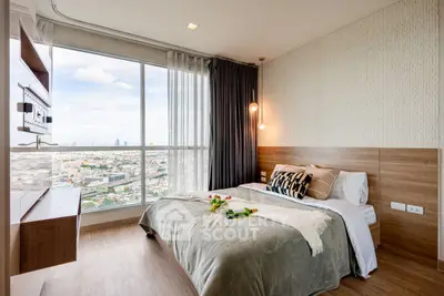 Modern bedroom with city view, stylish decor, and large window for natural light.