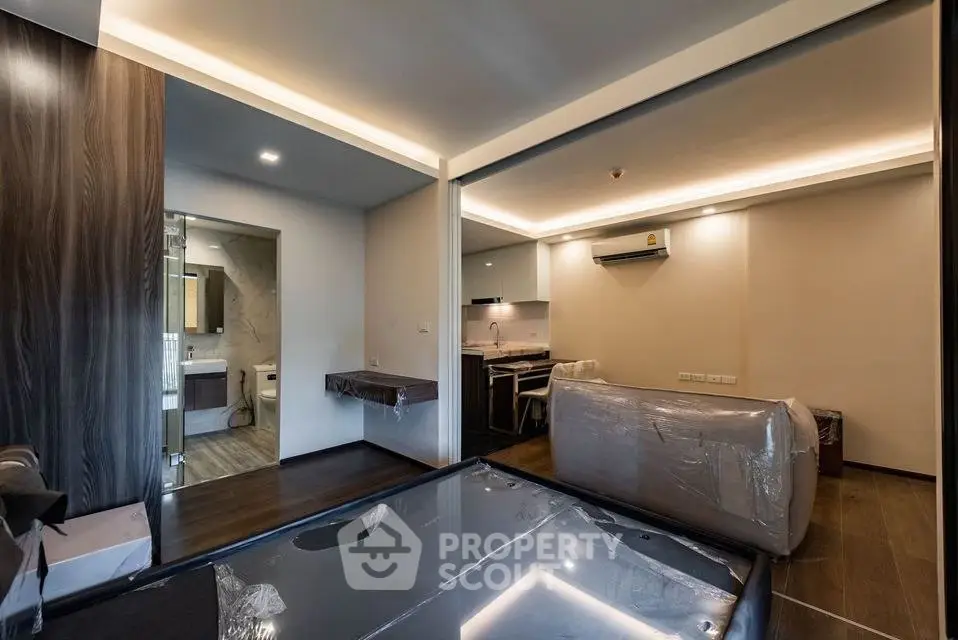Modern apartment interior with open layout and sleek design, featuring a partially furnished living area and kitchen.