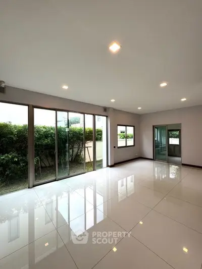 Spacious modern living room with large windows and garden view