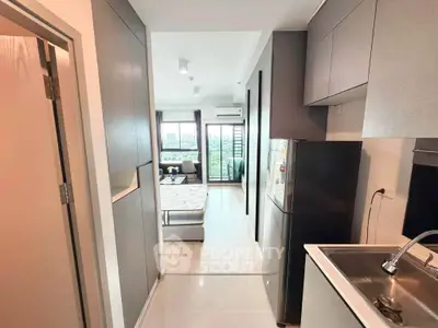 Modern studio apartment with sleek kitchen and bright living area, offering a stunning city view.