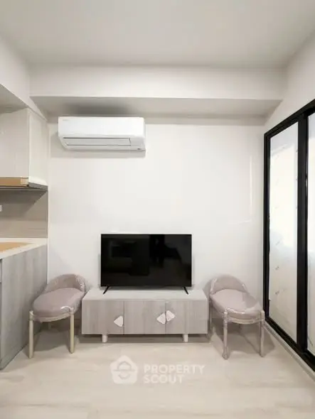 Modern living room with sleek TV setup and air conditioning, perfect for cozy relaxation.