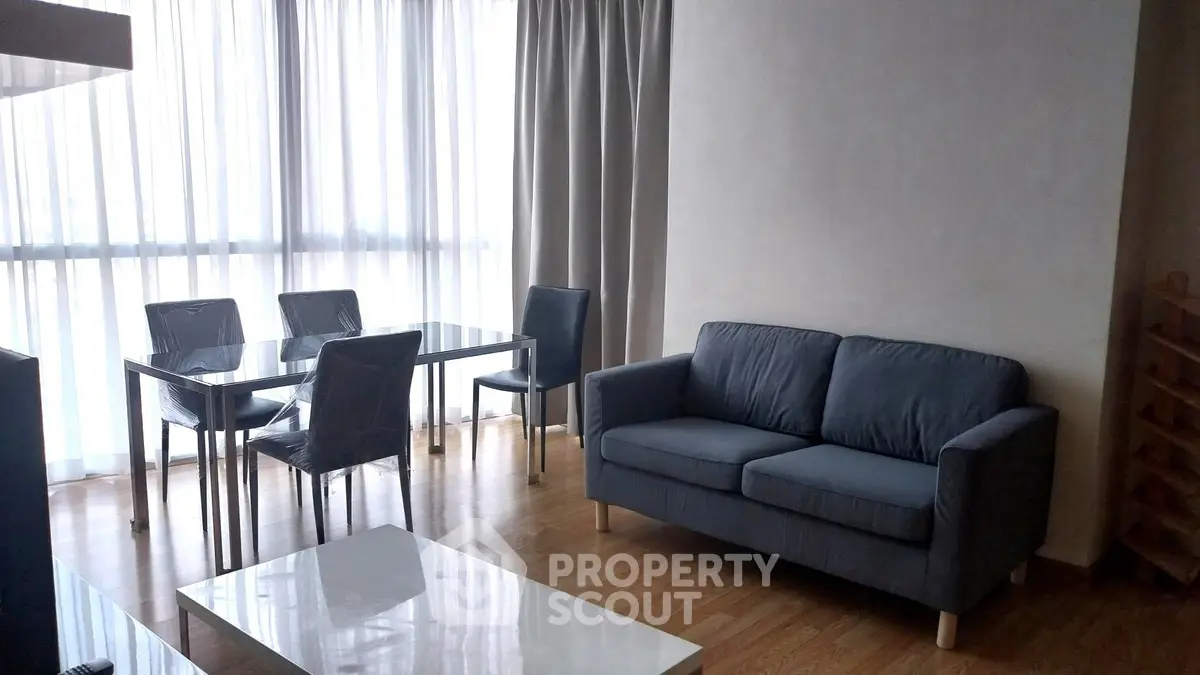 Modern living room with sleek furniture and large windows for natural light.